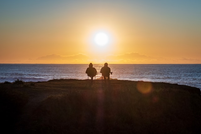 A retired couple watching the sunset enjoying funny retirement quotes